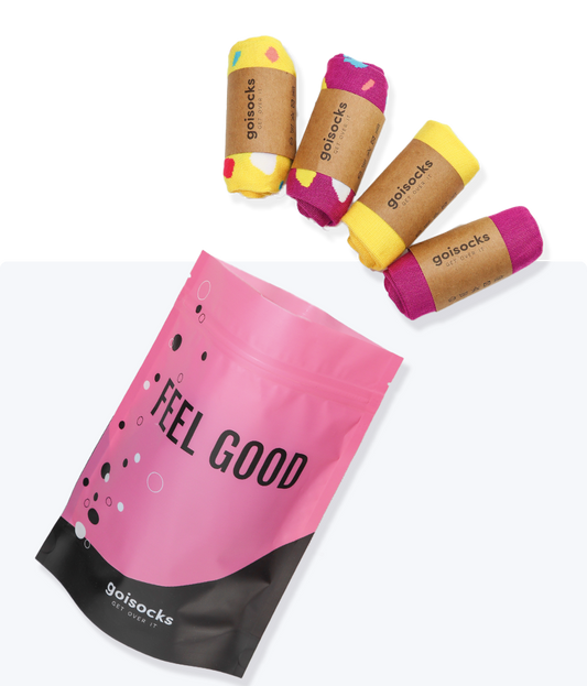 Goisocks Élénk Lila és Vibráló Sárga 4 darabos csomag gurigákban és rózsaszín zacskó, Feel Good felirattal.