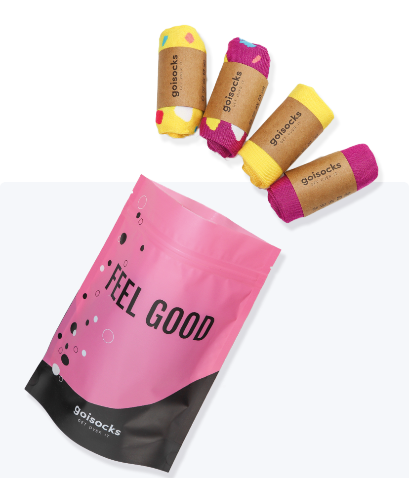 Goisocks Élénk Lila és Vibráló Sárga 4 darabos csomag gurigákban és rózsaszín zacskó, Feel Good felirattal.