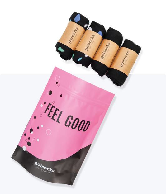 Goisocks Jól bevált Fekete 4 darabos csomag gurigákban és rózsaszín zacskó, Feel Good felirattal.