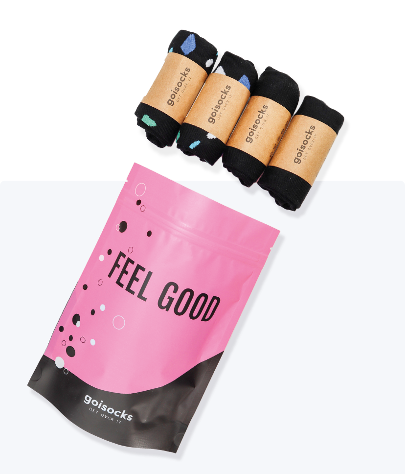 Goisocks Jól bevált Fekete 4 darabos csomag gurigákban és rózsaszín zacskó, Feel Good felirattal.