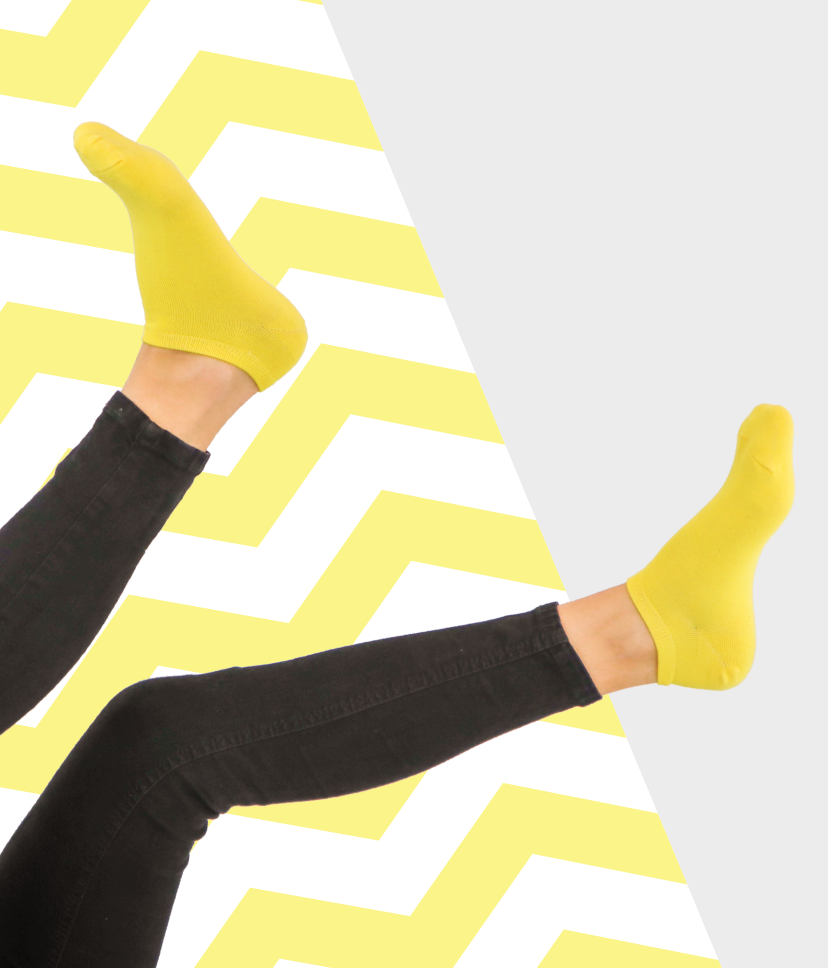 Felfelé álló lábakon egyszínű, vibráló sárga Goisocks bokazokni.