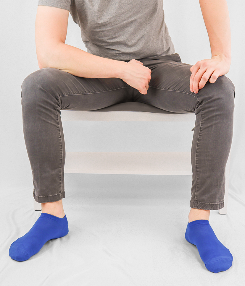 Egy férfi lábain egyszínű, csodás kék Goisocks bokazoknit visel.